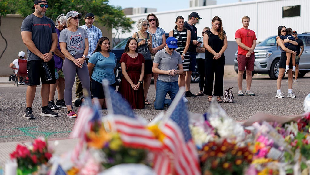 People pray at a memorial for Charlie Kirk at the Turning Point USA headquarters on Sept.12, 2025 in Phoenix. Kirk, the CEO and co-founder of Turning Point USA, was shot and killed on Wednesday in Utah.