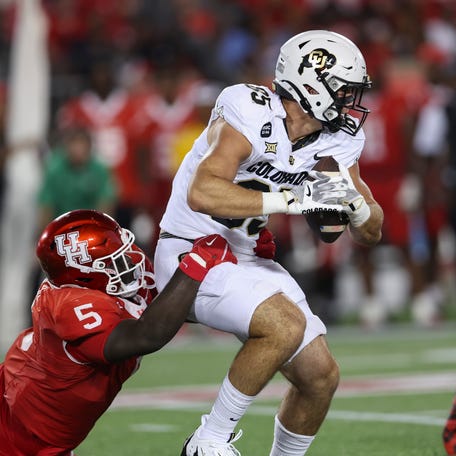 Colorado tight end Zach Atkins (85) runs with the ball as Houston Cougars defensive lineman Carlos Allen Jr. (5) attempts to make a tackle during the second quarter at TDECU Stadium.