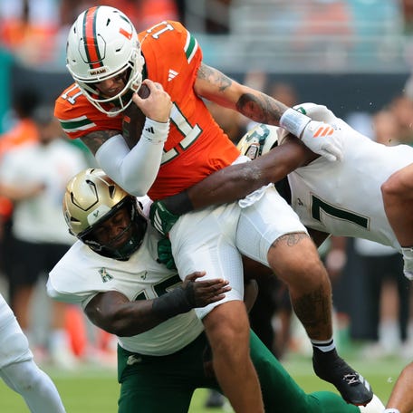Miami quarterback Carson Beck (11) runs with the ball against South Florida during the first quarter at Hard Rock Stadium.
