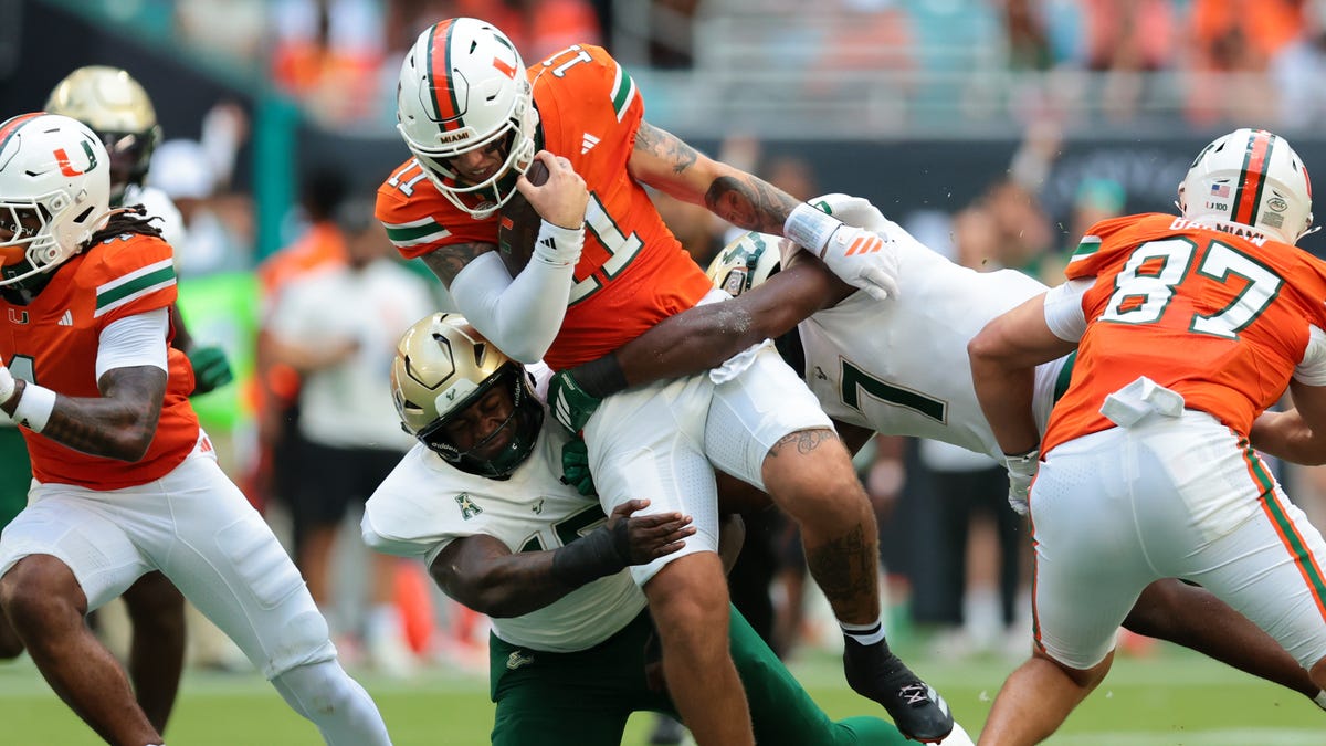 Miami quarterback Carson Beck (11) runs with the ball against South Florida during the first quarter at Hard Rock Stadium.
