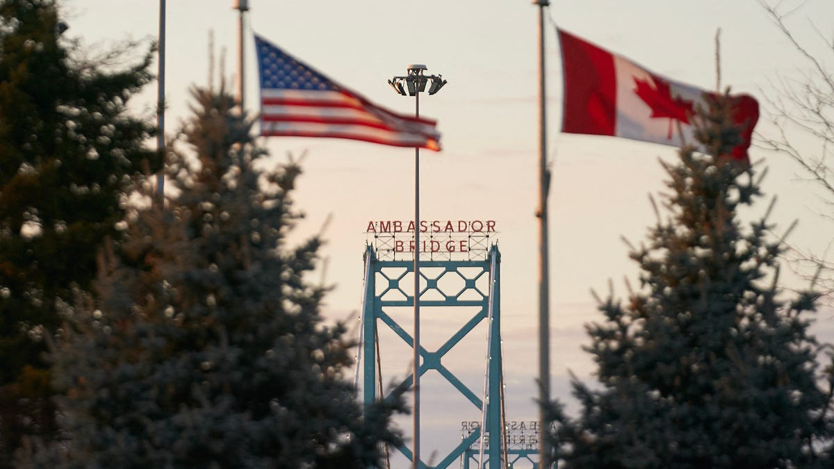 Canadian and American flags fly on the Canadian side of the Ambassador Bridge in Windsor, Ontario, on March 8, 2025.