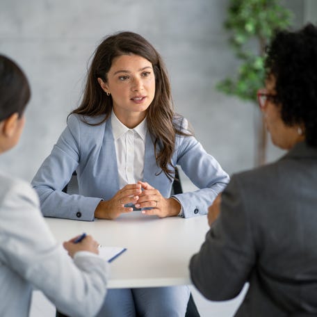 A businessperson actively listens and responds in a meeting in a corporate setting.