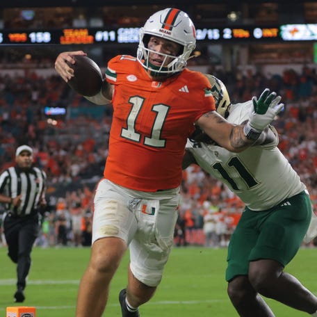 Miami quarterback Carson Beck (11) carries the football for a touchdown against South Florida during the second quarter at Hard Rock Stadium.