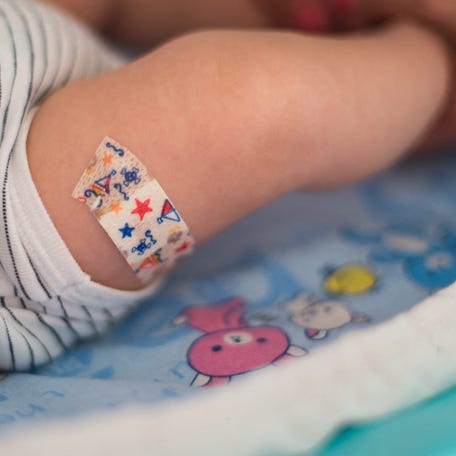 Illustration of a baby after his first vaccination with a bandage on his thigh in Paris, France, November 8, 2018.