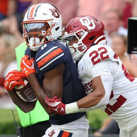Auburn wide receiver Cam Coleman (8) makes a catch and is tackled by Oklahoma defensive back Peyton Bowen (22) during their game at Jordan-Hare Stadium.