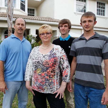 The Schramm family is seen in front of their home in Pembroke Pines, Florida February 7, 2012. (L-R): Robert, Martina, David and Nick Schramm. In this tough economy, it's not unusual to find baby boomers who are also part of the sandwich generation - squeezed from both sides. About 30 percent now contribute financially to their parents' care, according to the Pew Research Center. An even larger percentage provide   financial support to adult children. Picture taken February 7, 2012. REUTERS/Joe Skipper (UNITED STATES - Tags: BUSINESS SOCIETY)