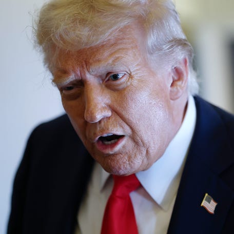 President Donald Trump is pictured speaking to reporters on Air Force One.