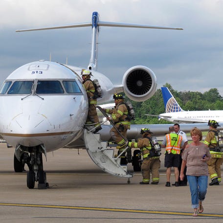 Passengers are evacuated as firefighters go aboard a CRJ 700 jet at Dulles International Airport in Dulles, Virginia after United Airlines flight 3783 from Dulles to Charlotte, North Carolina returned to the airport after smoke was reported in the plane during its flight, June 5, 2012.