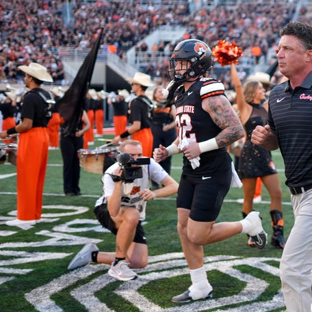 Oklahoma State head coach Mike Gundy runs on the field before an NCAA football game between Oklahoma State (OSU) and Tulsa at Boone Pickens Stadium in Stillwater, Okla., on Friday, Sept. 19, 2025.