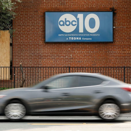 A car drives past a window that was covered by a board after it was stuck by gunfire at ABC10 (KXTV) in Sacramento, California on Sept. 19, 2025.