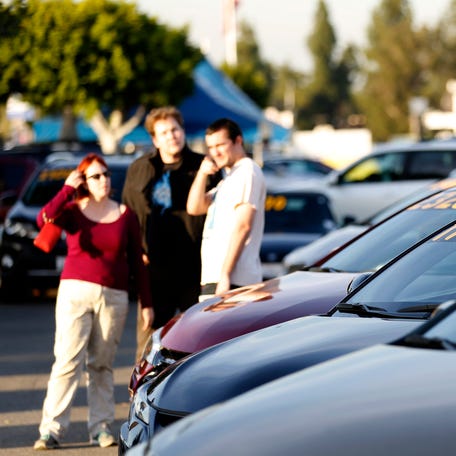 People look at vehicles for sale on the lot at AutoNation Toyota dealership in Cerritos, California December 9, 2015.