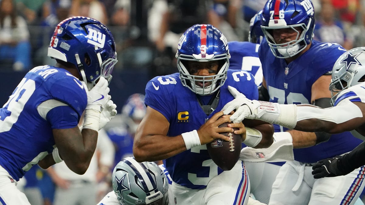 New York Giants quarterback Russell Wilson (3) is pressured by Dallas Cowboys defensive tackle Osa Odighizuwa (97) and defensive tackle Kenny Clark (95) at AT&T Stadium.
