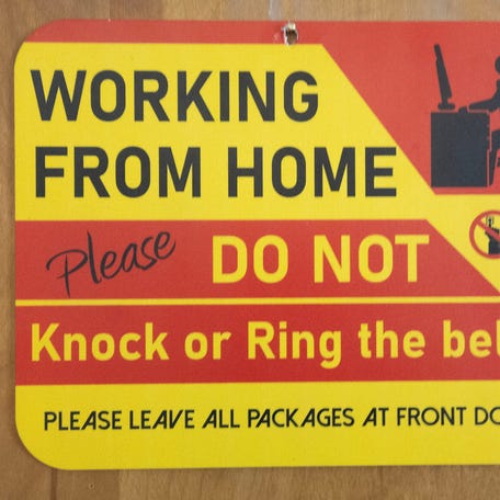 Shay Wilson hangs a sign on her North Canton apartment doors as she works from home Tuesday, March 4, 2024.