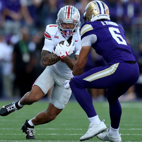 Ohio State wide receiver Brandon Inniss carries the ball as Washington defensive back Dylan Robinson during their game at Husky Stadium on Sept. 27, 2025 in Seattle.
