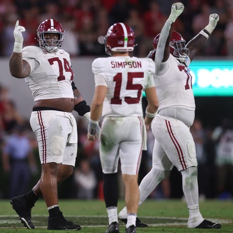 Alabmaa offensive lineman Kadyn Proctor (74) celebrates with quarterback Ty Simpson (15) after the team's defeat of Georgia at Sanford Stadium.