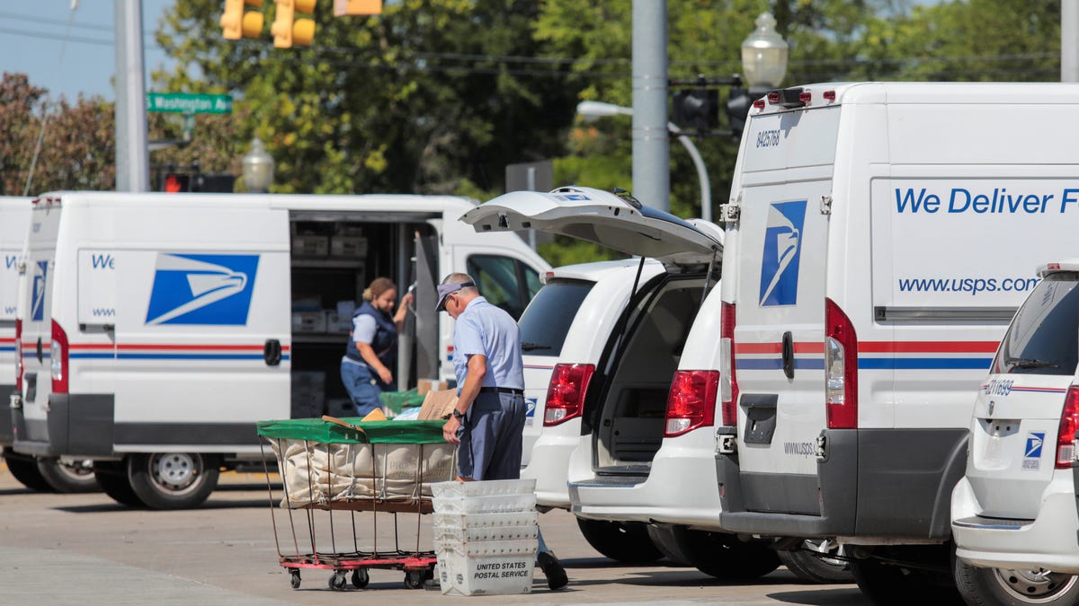 United States Postal Service (USPS) workers load mail into delivery trucks outside a post office in Royal Oak, Michigan, U.S. August 22, 2020.