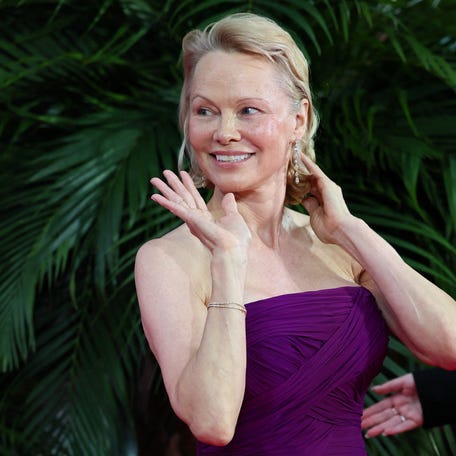 Pamela Anderson waves as she attends the UK premiere of "The Naked Gun" at the Cineworld Leicester Square in London on July 22, 2025.