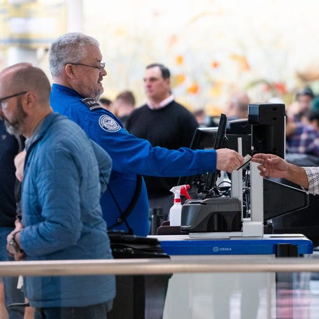 A TSA agent scans the ID of a traveler Wednesday, May 7, 2025, inside Concourse A at Indianapolis International Airport.