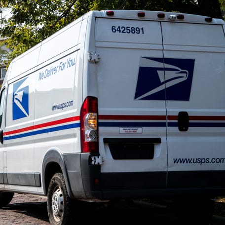 A United States Postal Service (USPS) van parks on E. Davenport Street during a delivery, Tuesday, Aug. 25, 2020, in Iowa City, Iowa.