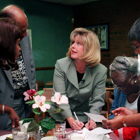 Tipper Gore, center, takes time to sign a card while on a visit to Swett's Restaurant in Nashville to talk to seniors about Medicare on July 31, 1996.