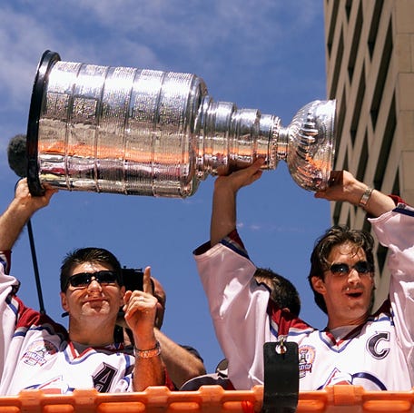 Ray Bourque, left, and Joe Sakic lift the Stanley Cup during the Colorado Avalanche's 2001 Stanley Cup parade.