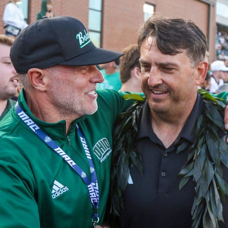 Ohio football coach Brian Smith celebrates with fans after defeating the West Virginia at Peden Stadium.