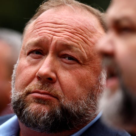 Infowars founder Alex Jones listens as his attorney speaks to reporters after they appeared it Connecticut Superior Court in Waterbury in 2022.