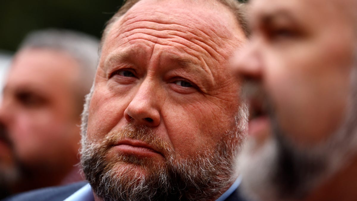 Infowars founder Alex Jones listens as attorney Robert Barnes speaks to the media after Jones appeared at his Sandy Hook defamation trial at Connecticut Superior Court in Waterbury, Connecticut, U.S., October 4, 2022.