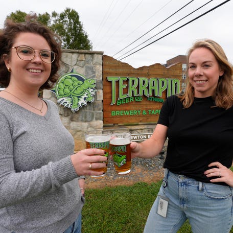 Angela Harris, a quality assurance manager, and Caitlyn Moss, a quality assurance technician, at Terrapin Brew Company's beer lab cheers in Athens, Georgia, Oct. 9, 2025.