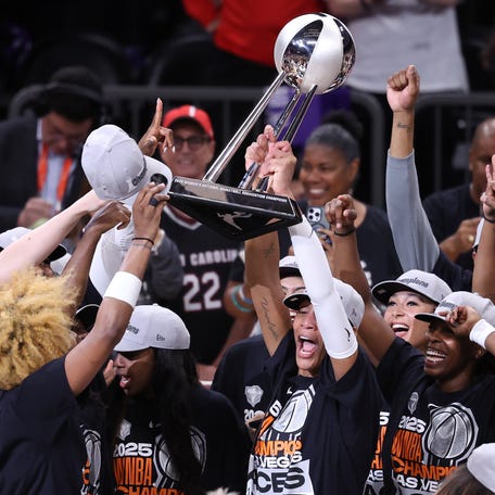PHOENIX, ARIZONA - OCTOBER 10: A'ja Wilson #22 of the Las Vegas Aces holds up the championship trophy after winning Game Four of the 2025 WNBA Playoffs finals at Mortgage Matchup Center on October 10, 2025 in Phoenix, Arizona. The Las Vegas Aces defeat the Phoenix Mercury 97-86 to win the championship. (Photo by Chris Coduto/Getty Images)