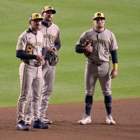 Milwaukee Brewers shortstop Joey Ortiz (3), second baseman Brice Turang (2) and third baseman Caleb Durbin (21) watch a replay during Game 4 of the NLDS.