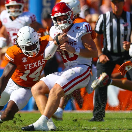 Texas linebacker Brad Spence (14) looks to tackle Oklahoma quarterback John Mateer (10) during the first half at the Cotton Bowl.