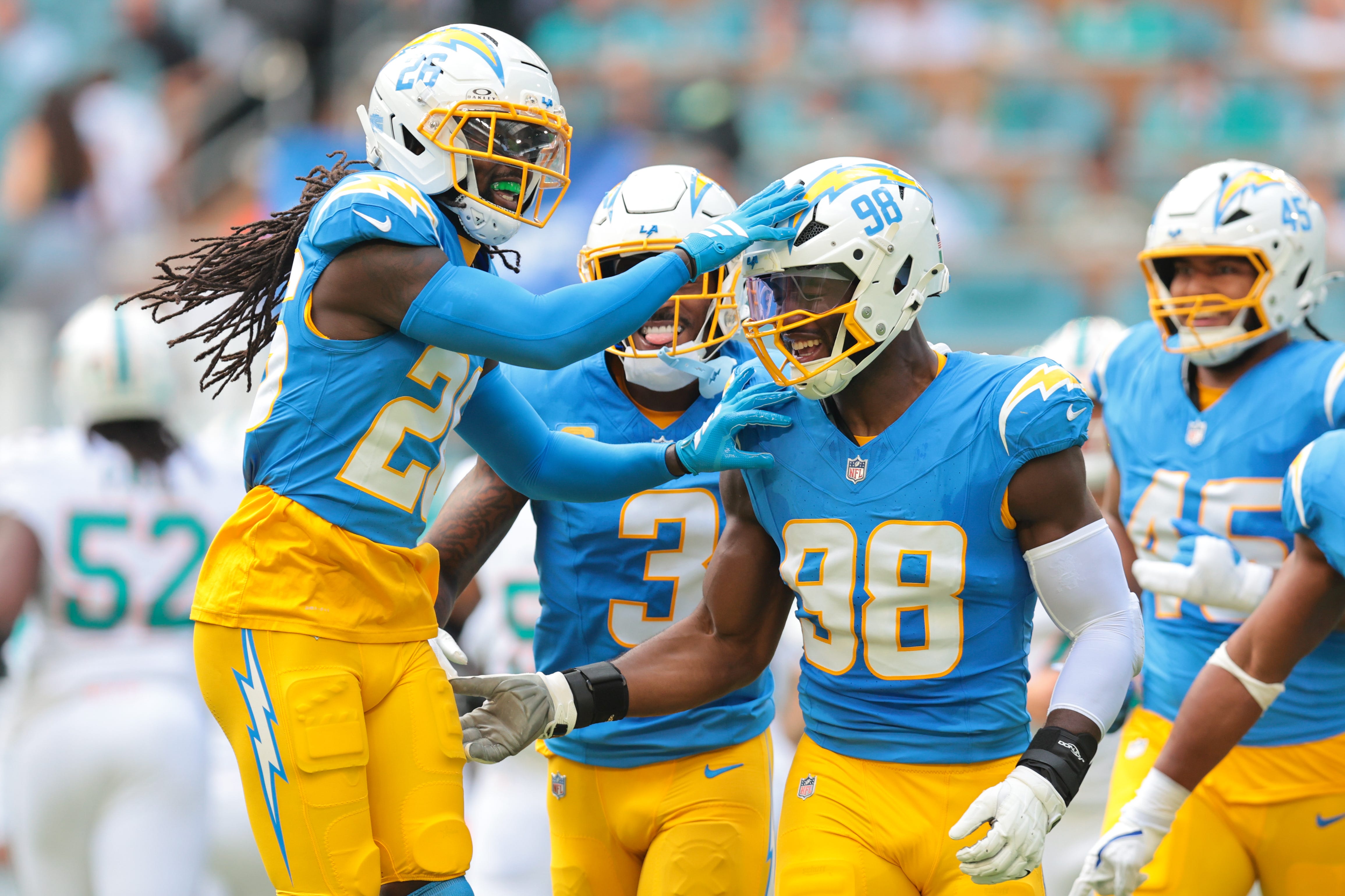 Oct 12, 2025; Miami Gardens, Florida, USA; Los Angeles Chargers offensive linebacker 
Odafe Oweh (98) celebrates with cornerback Donte Jackson (26) after a sacking Miami Dolphins quarterback Tua Tagovailoa (not pictured) during the first quarter at Hard Rock Stadium. Mandatory Credit: Sam Navarro-Imagn Images