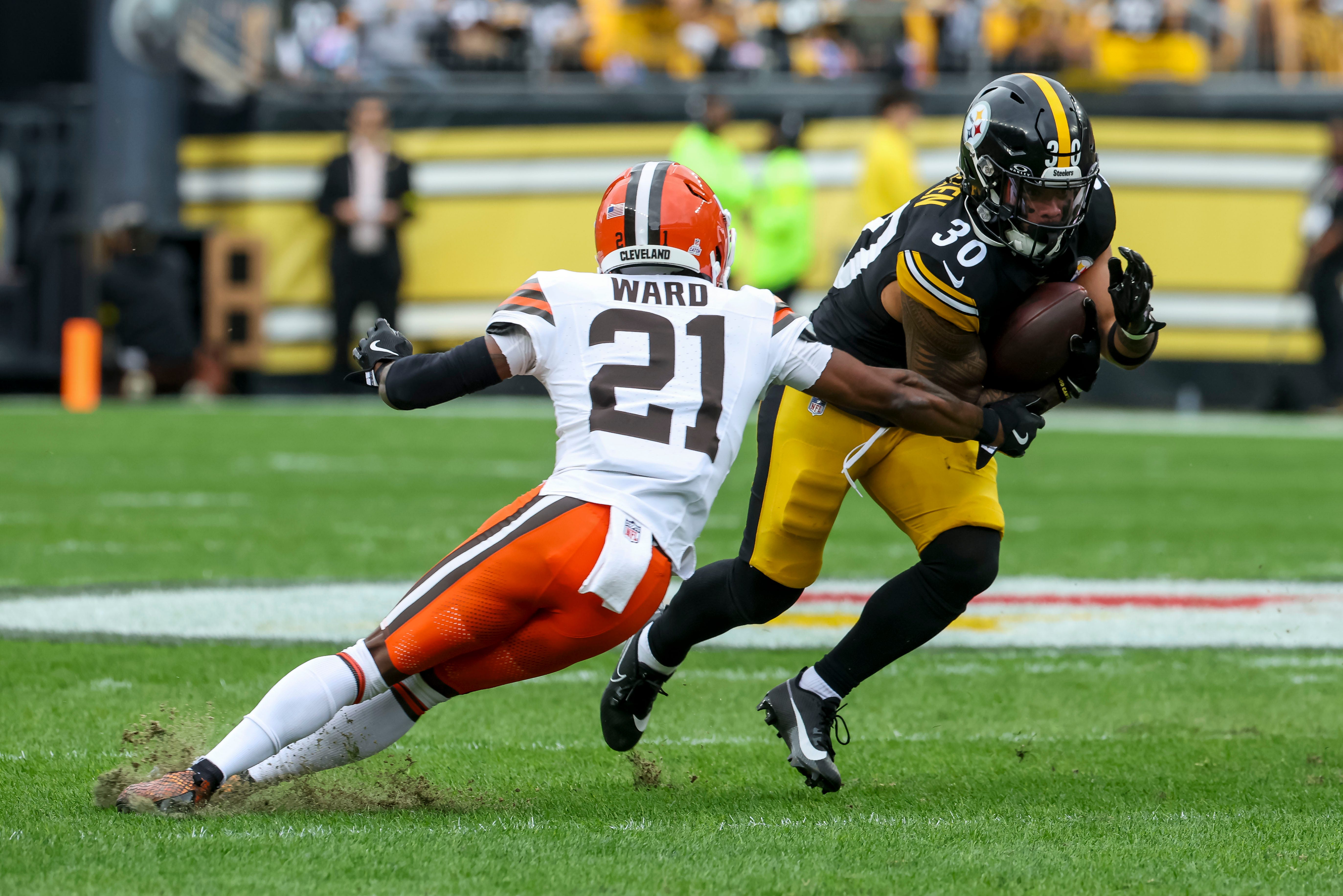 Oct 12, 2025; Pittsburgh, Pennsylvania, USA; Pittsburgh Steelers running back Jaylen Warren (30) runs the ball while Cleveland Browns cornerback Denzel Ward (21) defends during the first quarter at Acrisure Stadium. Mandatory Credit: Charles LeClaire-Imagn Images