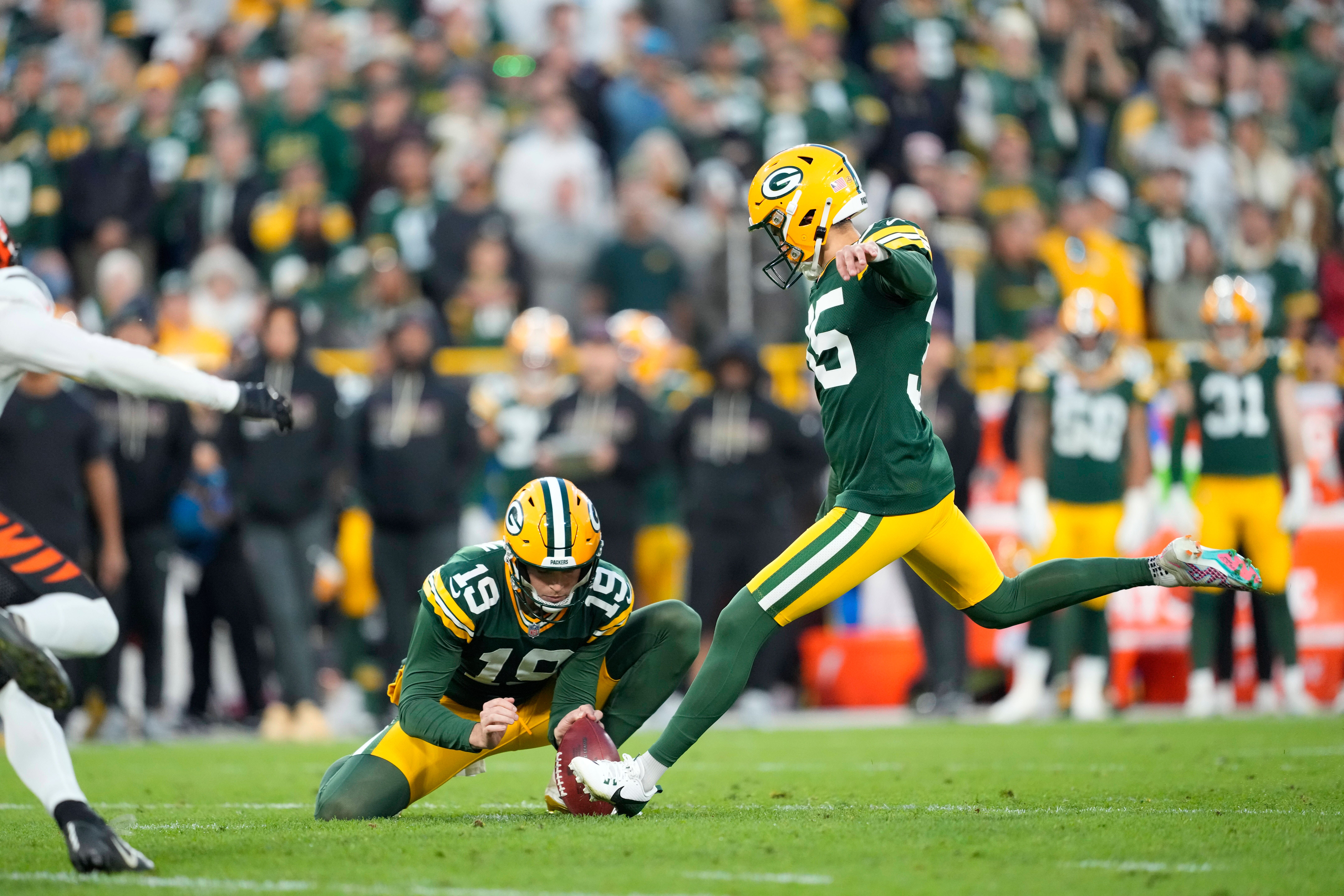 Oct 12, 2025; Green Bay, Wisconsin, USA; Green Bay Packers kicker Lucas Havrisik (35) kicks a field goal with punter Daniel Whelan (19) in the fourth quarter against the Cincinnati Bengals at Lambeau Field. Mandatory Credit: Jeff Hanisch-Imagn Images