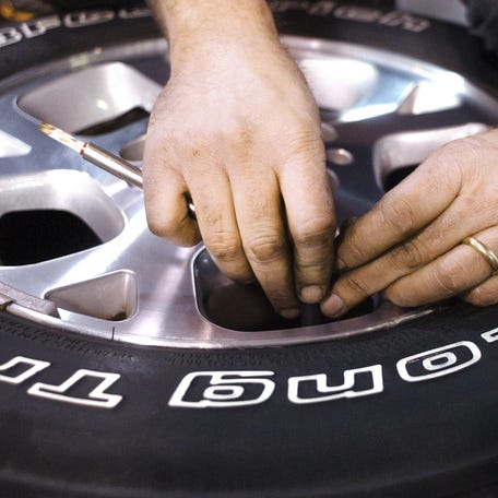 Shannon Roley, an Automotive Service Excellence Master Technician at Kumler Automotive, takes a tire pressure reading during a winter inspection and service on Friday, October 28.