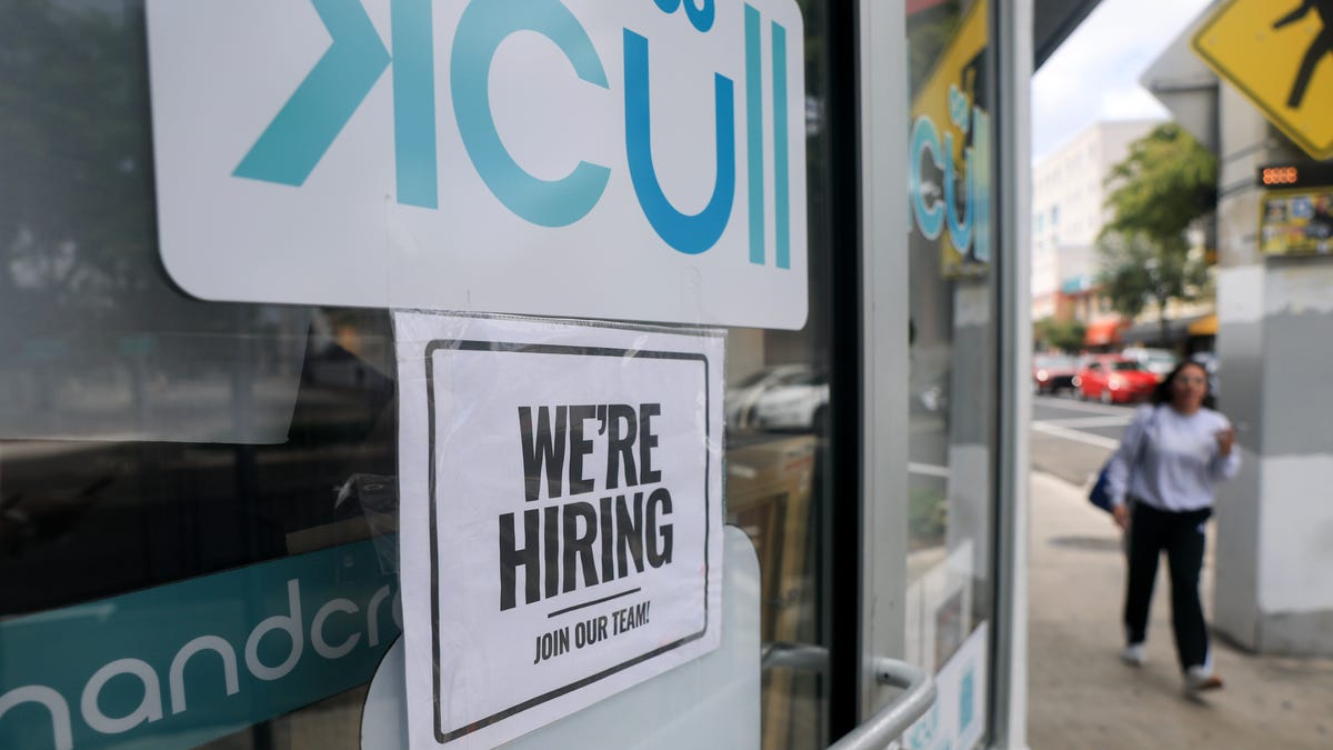 A 'We're Hiring' sign is taped to the window of a business on October 03, 2025 in Miami, Florida. Due to the U.S. Government shutdown the Bureau of Labor Statistics will not be releasing September's employment data. (Photo by Joe Raedle/Getty Images)
