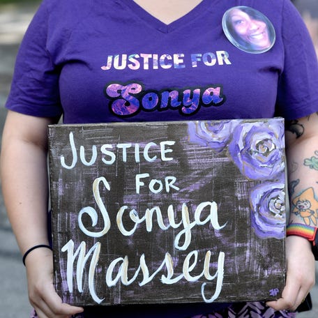 Erin Pacha of Springfield holds a sign at the balloon release for Sonya Massy on the anniversary of her death Sunday, July 6, 2025.