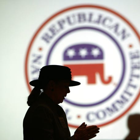 Republican Party members are silhouetted against the Republican National Committee (RNC) logo at the RNC 2006 annual winter meeting at a hotel in Washington January 20, 2006.