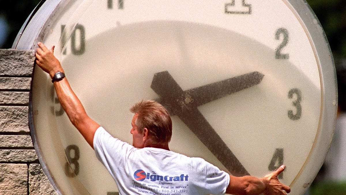 Joe Roskey of Sign Craft, of Riviera Beach, Fla. works on the outdoor clock at the First Federal Savings and Loans, at the corner of Olive Avenue and Southern Blvd in this photo circa April 1999.