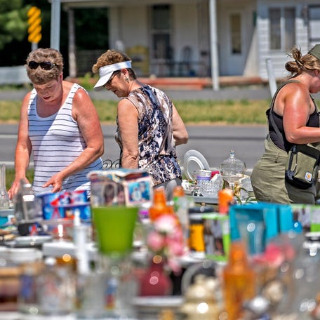 Shoppers check out all the items on tables at a sale in Charlottesville, Friday, June 2, 2023 during the annual Historic National Road Yard Sale on U.S. 40. In 2003, the Indiana National Road Association started the national yard sale to promote tourism on the national road, promoting the towns, communities, businesses and the people along U.S. 40.