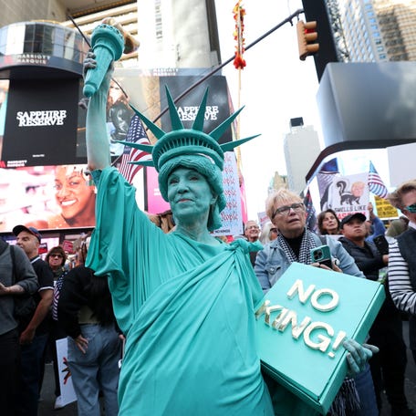 A person dressed in a Statue of Liberty costume participates in a "No Kings" national day of protest in New York on Oct. 18, 2025.