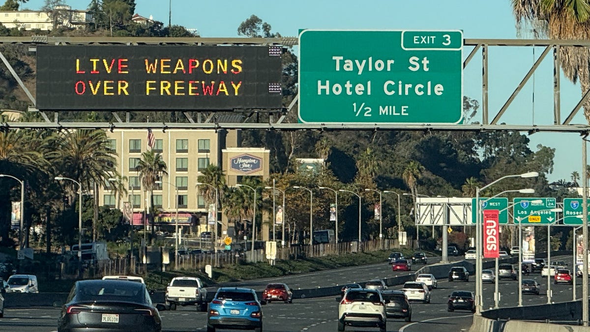 Freeway signs warn drivers on Interstate 8 approaching Interstate 5 of "Live Weapons Over Freeway" in San Diego, California on October 18, 2025.
