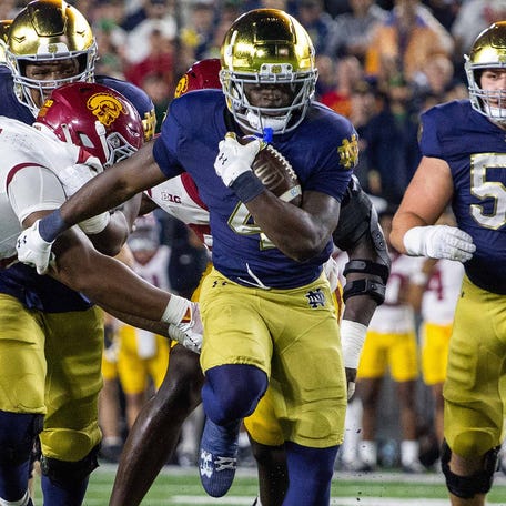 Notre Dame running back Jeremiyah Love (4) runs the ball as Southern California defensive tackle Jide Abasiri (97) tries to make a tackle during the first half at Notre Dame Stadium.\