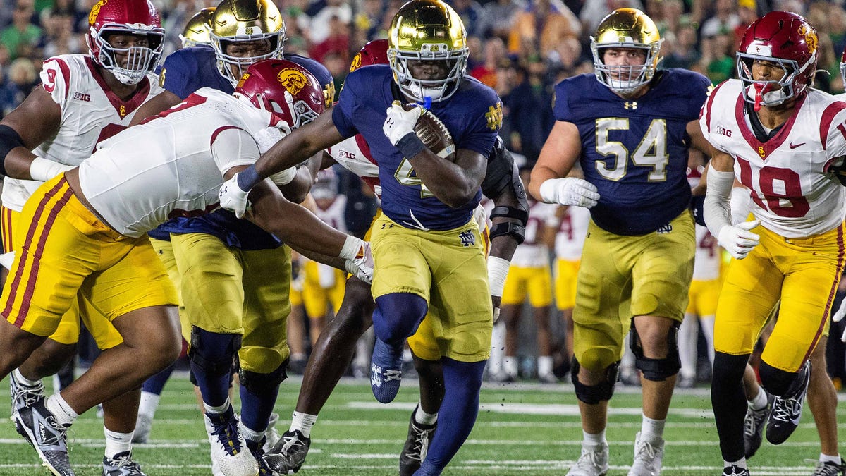 Notre Dame running back Jeremiyah Love (4) runs the ball as Southern California defensive tackle Jide Abasiri (97) tries to make a tackle during the first half at Notre Dame Stadium.\