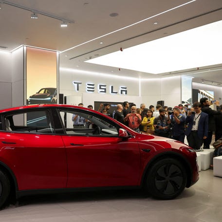 Media personnel take pictures and videos of the TESLA Model Y car at India's first Tesla showroom in Mumbai, India, July 15, 2025.