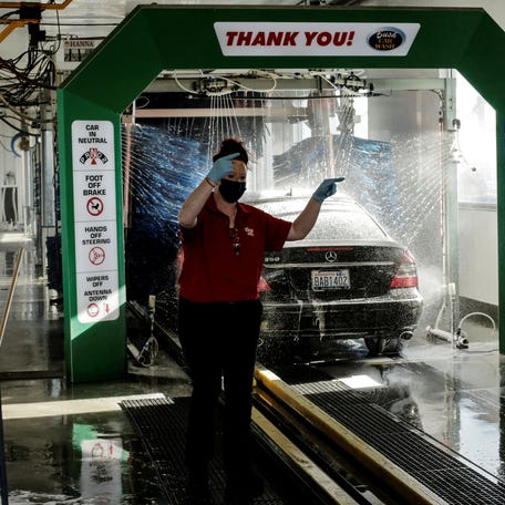 Jarae Phillips directs a car at Bush Car Wash, which reopened after Franklin County commissioners voted to end recognition of Governor Jay Inslee's "Stay Home, Stay Healthy" mandate and allow businesses to reopen, during the coronavirus disease (COVID-19) outbreak, in Pasco, Washington, U.S. April 22, 2020. REUTERS/David Ryder REFILE - CORRECTING LOCATION