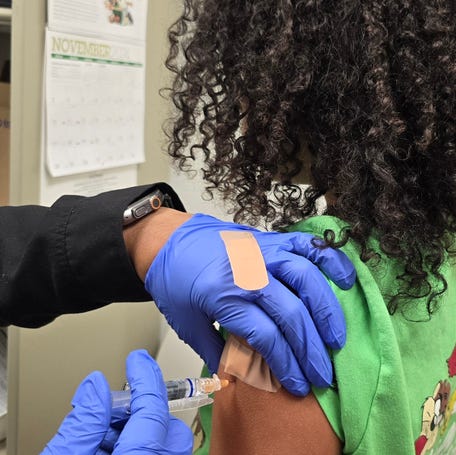 A child receives one of two vaccinations for flu and COVID-19 at the Cumberland County Department of Public Health in Fayetteville, North Carolina.