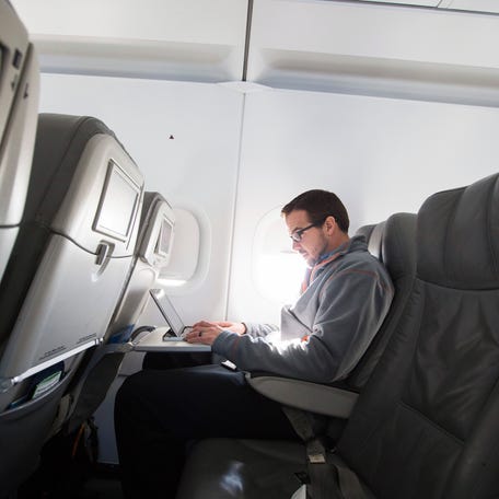A passenger uses his laptop to test a new high-speed in-flight internet service named Fly-Fi while on a special JetBlue media flight out of John F. Kennedy International Airport in New York, Dec. 11, 2013.