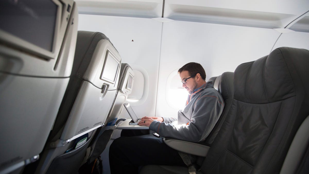A passenger uses his laptop to test a new high-speed in-flight internet service named Fly-Fi while on a special JetBlue media flight out of John F. Kennedy International Airport in New York, Dec. 11, 2013.
